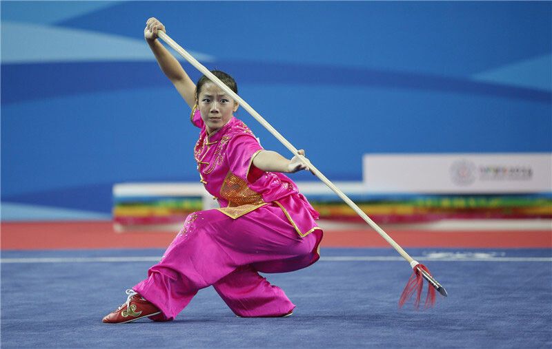 Competidora de wushu con lanza en plena ejecución de un Tao Lu